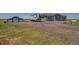 Gravel driveway leads to a charming single-story home with a detached garage and parked RV at 11809 Pass Me By Rd, Strasburg, CO 80136