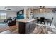 This kitchen has an island, bar seating and flows into the living room and dining room at 11809 Pass Me By Rd, Strasburg, CO 80136