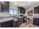 A charming kitchen with stainless sink, updated appliances, and adjacent laundry room at 11809 Pass Me By Rd, Strasburg, CO 80136