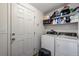 Practical laundry room with modern washer and dryer units, plus shelving for storage at 11809 Pass Me By Rd, Strasburg, CO 80136