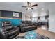 Inviting living room boasts a leather sofa and an open view to the kitchen at 11809 Pass Me By Rd, Strasburg, CO 80136