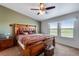 Bright main bedroom featuring a decorative wood bed frame and a scenic outside view at 11809 Pass Me By Rd, Strasburg, CO 80136