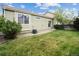 Well-maintained backyard with lush green lawn, mature trees, and a patio area, perfect for outdoor enjoyment and relaxation at 15594 E 97Th Ave, Commerce City, CO 80022