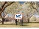 Neighborhood view of Badger Park sign surrounded by white flowering trees and residential homes at 15594 E 97Th Ave, Commerce City, CO 80022