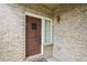 Close-up of a wooden front door showcasing the brick facade and exterior light fixture at 15594 E 97Th Ave, Commerce City, CO 80022