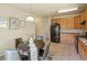 Functional kitchen area with wood cabinetry, black appliances, and adjacent dining space at 15594 E 97Th Ave, Commerce City, CO 80022