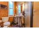 This bathroom features red brick and a stylish pedestal sink with convenient storage at 233 W 3Rd Ave, Denver, CO 80223