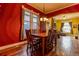 Elegant dining room with hardwood floors, bright red walls, and an adjacent view into the living room at 233 W 3Rd Ave, Denver, CO 80223