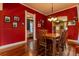 Red dining room featuring a wooden table set for six, hardwood flooring, and bright natural light at 233 W 3Rd Ave, Denver, CO 80223