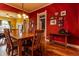 The dining area offers hardwood floors, red walls, a wine rack and is adjacent to the living area at 233 W 3Rd Ave, Denver, CO 80223