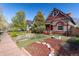 Charming home with landscaped front yard, featuring a well-maintained lawn and decorative garden beds at 233 W 3Rd Ave, Denver, CO 80223