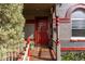 Inviting front porch with a red door, decorative columns, and a welcoming 