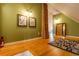 Hallway with hardwood floors, brick pillar, green walls, and eye-catching artwork at 233 W 3Rd Ave, Denver, CO 80223