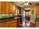 Cozy kitchen includes wood cabinets, dark countertops, wooden floors, and an open layout at 233 W 3Rd Ave, Denver, CO 80223