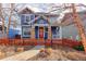 Inviting two-story home with a colorful exterior, a red front door, and tidy landscaping at 5068 Uinta St, Denver, CO 80238