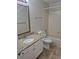 Bathroom with single vanity and tub shower featuring stylish, neutral wall and floor tiles at 2238 S Nile Ct, Aurora, CO 80014