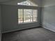 Bedroom boasting a large window and neutral gray walls complemented by gray carpet at 2238 S Nile Ct, Aurora, CO 80014