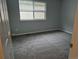 Bedroom featuring neutral gray walls, a gray carpet, and a window, creating a bright and airy feel at 2238 S Nile Ct, Aurora, CO 80014