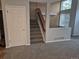 Entryway featuring a staircase and a doorway, complementing the gray carpet and unique paneled accent wall at 2238 S Nile Ct, Aurora, CO 80014