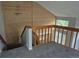 Loft showcasing a wooden railing, with gray carpet complementing the natural light from the window for a serene space at 2238 S Nile Ct, Aurora, CO 80014