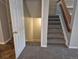View of the home's carpeted staircase with wood handrail and the entrance to a lower level beneath the stairs at 2238 S Nile Ct, Aurora, CO 80014