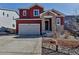 Inviting two-story home featuring a two-car garage and stone-clad entryway at 4840 Point Mesa St, Castle Rock, CO 80108