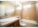 Bathroom features a large mirror, single vanity, and shower-tub combo with tiled surround at 8387 Fig St, Arvada, CO 80005
