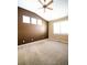 Bright bedroom with vaulted ceilings features neutral carpet, a ceiling fan, and three sunny windows at 8387 Fig St, Arvada, CO 80005