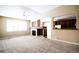 Spacious living room with a fireplace, large window, and seamless view into the kitchen at 8387 Fig St, Arvada, CO 80005