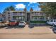 Condominium exterior featuring balconies, stone accents, parking spaces, and manicured green spaces at 904 S Walden Way # 203, Aurora, CO 80017