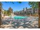 Community pool surrounded by lush landscaping and a variety of lounge chairs at 904 S Walden Way # 203, Aurora, CO 80017
