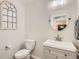 Cozy bathroom with a stylish gray vanity, round mirror, and decorative window, complemented by neutral wall color at 6187 Wescroft Ave, Castle Rock, CO 80104