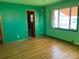Bedroom with green walls, hardwood floors, and window at 6397 Ute Hwy, Longmont, CO 80503