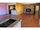 Hardwood floor living room with stone fireplace and kitchen view at 6397 Ute Hwy, Longmont, CO 80503