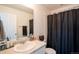 Simple bathroom featuring a single sink, mirror, and shower with a black curtain at 26985 E Bayaud Ave, Aurora, CO 80018