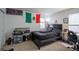 Bedroom with a black bed, Mexican flag, and a desk, offering a personal space at 26985 E Bayaud Ave, Aurora, CO 80018