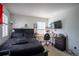 Bedroom featuring a black bed, desk, and TV, creating a comfortable and functional space at 26985 E Bayaud Ave, Aurora, CO 80018