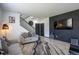 Comfortable living room featuring a staircase and stylish accent wall with mounted TV at 26985 E Bayaud Ave, Aurora, CO 80018