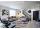 Cozy living room features a staircase, contemporary furnishings, and ample natural light at 26985 E Bayaud Ave, Aurora, CO 80018