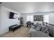 Cozy living room with a comfortable gray couch, a TV, and a desk by the window at 26985 E Bayaud Ave, Aurora, CO 80018
