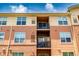 Close-up of a three-story condo featuring upper and lower balconies on a warm sunny day at 4100 Albion St # 523, Denver, CO 80216