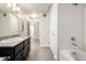 Well-lit bathroom with a granite vanity, wood-look flooring, and tiled tub with shower at 4100 Albion St # 523, Denver, CO 80216