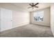 Spacious bedroom with plush carpeting, a ceiling fan, and natural light from a window at 4100 Albion St # 523, Denver, CO 80216
