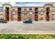 Apartment building exterior with balconies and parking area on a partially sunny day at 4100 Albion St # 523, Denver, CO 80216