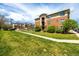 Apartment building exterior featuring landscaped lawn with sidewalk and trees, under bright blue sky at 4100 Albion St # 523, Denver, CO 80216