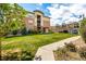 Apartment building exterior featuring landscaped lawn with sidewalk and trees, under bright blue sky at 4100 Albion St # 523, Denver, CO 80216