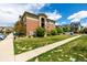 Apartment building exterior featuring landscaped lawn with sidewalk and trees, under bright blue sky at 4100 Albion St # 523, Denver, CO 80216
