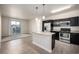 Modern kitchen with stainless steel appliances, granite countertops, and an island overlooking the living area at 4100 Albion St # 523, Denver, CO 80216