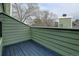 Outdoor balcony with a wood-slat floor and green wood-panel siding at 4108 S Rifle Way, Aurora, CO 80013