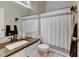 Well-lit bathroom with a modern vanity, framed mirror, and stylish shower curtain at 4108 S Rifle Way, Aurora, CO 80013